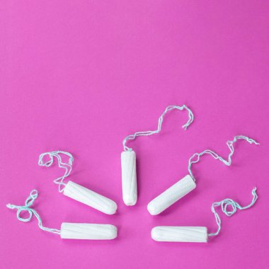 Kadın hijyen koruması, pembe arka planda pamuk tamponlar..