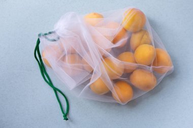 Çevre dostu ambalajlarda kayısı. Sebze ve meyveler için yeniden kullanılabilir çantalar. Mağazada alışveriş, perakende. Çevre dostu ambalaj.