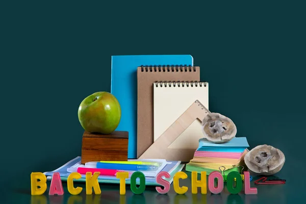 학교로 돌아가기 비문. 학교 용품과 정물 생활. 녹색 배경입니다. 노트북, 노트북, 펠트 팁 펜, 색연필, 사과. 다채로운 그림. — 스톡 사진