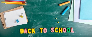 Afiş. Hala okul malzemeleri ile hayat. Tahta tebeşir Chalkboard. Yeşil arka plan. Notebooklar, notebooklar, keçe uçlu kalemler, renkli kalemler. Okul yılı başlangıcı.
