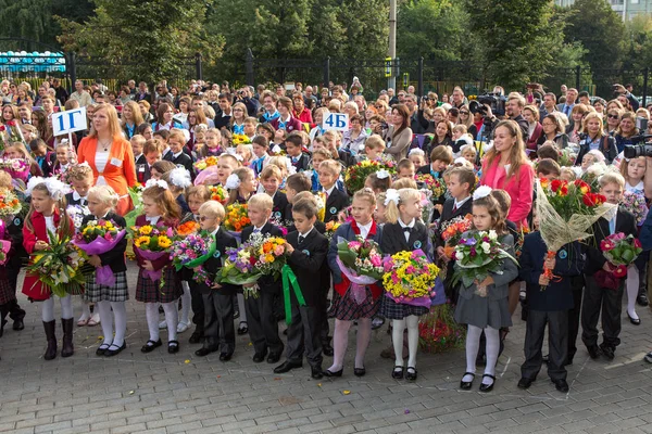 Mosca, Russia - 1 SETTEMBRE 2013: Incontro con gli alunni di prima elementare e gli insegnanti nel cortile della scuola. Il giorno della conoscenza in Russia. Bambini con fiori . — Foto Stock