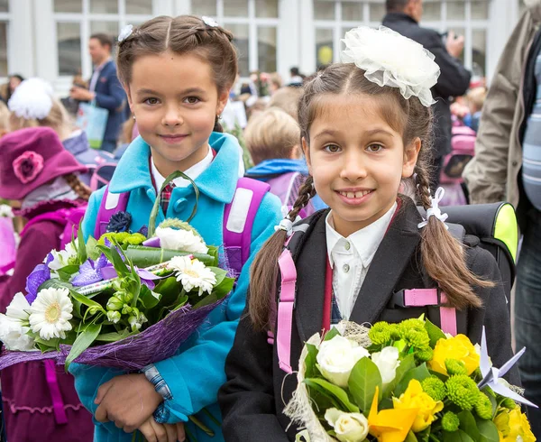 Moskwa, Rosja-SEP, 1, 2014: spotkanie z uczniami pierwszej klasy i nauczycielem na Schoolyard. Dzień wiedzy w Rosji. Dzieci z kwiatami. — Zdjęcie stockowe