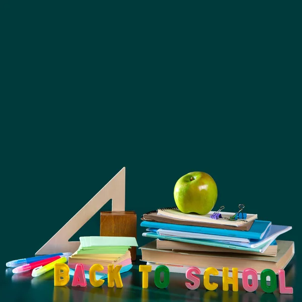 Επιγραφή πίσω στο σχολείο. Ακόμα ζωή με σχολικές προμήθειες. Σημειωματάρια, σημειωματάρια, στυλό, χρωματιστά μολύβια, ένα μήλο. Πολύχρωμη εικόνα. Αντιγραφή χώρου — Φωτογραφία Αρχείου
