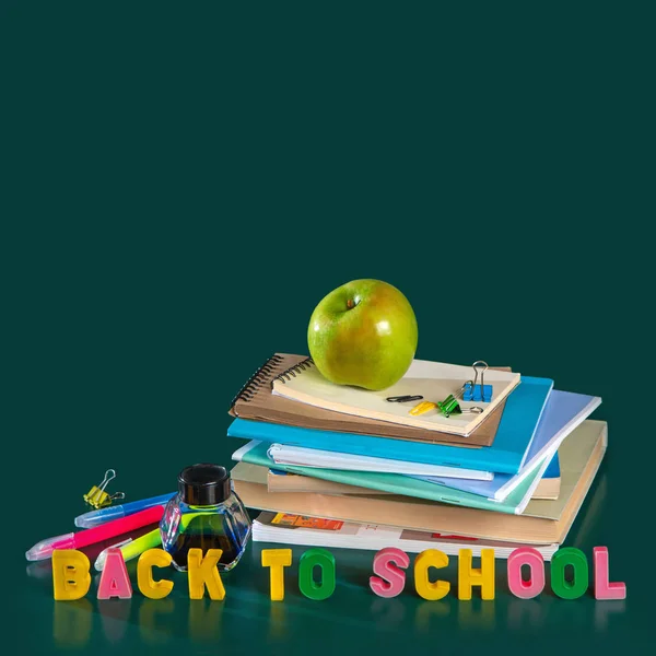 Επιγραφή πίσω στο σχολείο. Ακόμα ζωή με σχολικές προμήθειες. Σημειωματάρια, σημειωματάρια, στυλό, χρωματιστά μολύβια, ένα μήλο. Πολύχρωμη εικόνα. Αντιγραφή χώρου — Φωτογραφία Αρχείου