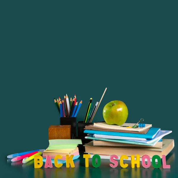Надпись "Назад в школу". Натюрморт со школьными принадлежностями. Ноутбуки, блокноты, ручки с войлочными кончиками, цветные карандаши, яблоко. Красочная картина. Копирование пространства — стоковое фото