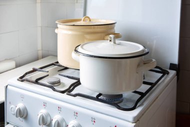 Gaz sobasının üzerinde iki tane mayalı tava duruyor. Evde doğal gaz var.. 