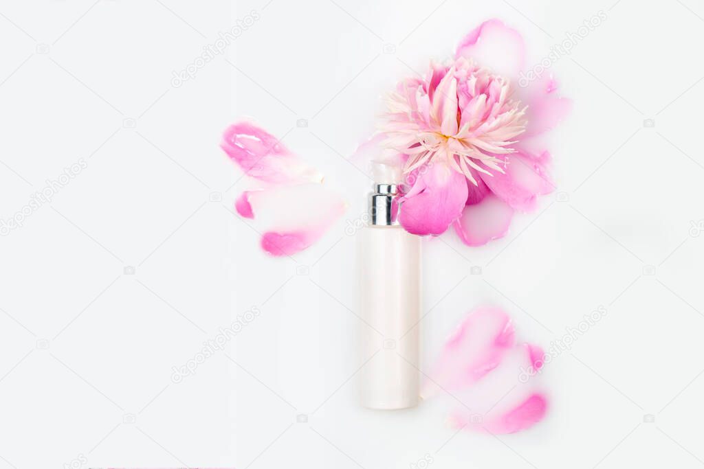 Jar of cream and pink peony in a milk bath. Conceptual photo: the best cosmetic tool for body and face care. Gentle care. Copy space, flat lay. Natural cosmetics, mock up.