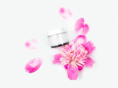 Sütlü bir banyoda krema ve şakayık çiçeği. Kavramsal fotoğraf: vücut ve yüz bakımı için en iyi kozmetik araç. Nazikçe. Doğal kozmetik ürünleri. Düz.