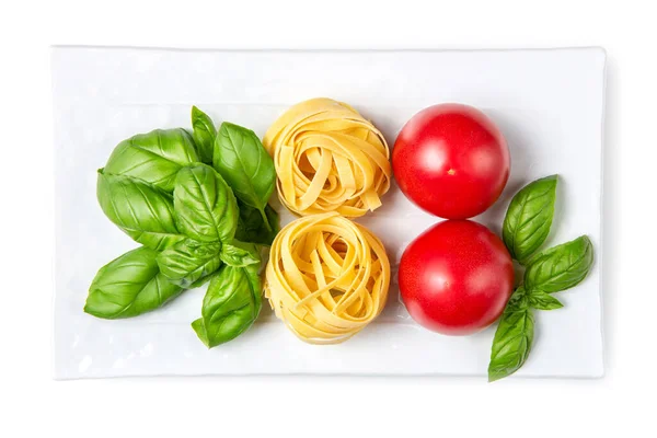 罗勒叶 意大利面 西红柿在白盘上 白色孤立的背景 意大利国旗的颜色 复制空间 意大利面的配料 — 图库照片