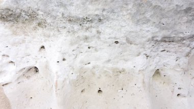 Beyaz doğal taşın dokusundan hafif bir arkaplan ve metin için yer var. Tasarım şablonu için pürüzsüz kabataslak taşın dokusu.