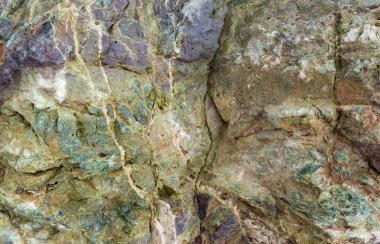 Yeşil Jasper veya Gabbro Diabase 'in taş dokusu. Eski kaya taşının güzel gri-yeşil arka planı. Çatlakları ve oyukları olan taş. Peyzaj yapmak için kayanın içindeki antik mineral..