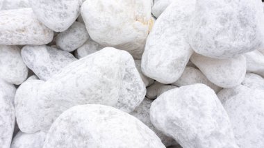 Beyaz mermer taşlar. Beyaz mermer taşların dokusuna sahip beyaz soyut bir arka plan. Doğal devrilmiş mermer taşlarla iç ve dış dekorasyon..