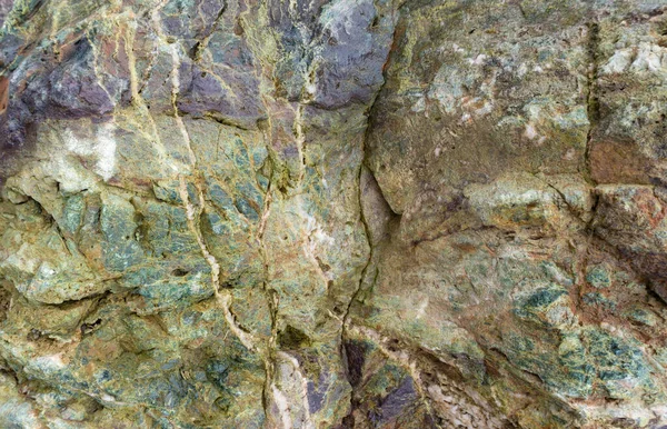 Yeşil Jasper veya Gabbro Diabase 'in taş dokusu. Eski kaya taşının güzel gri-yeşil arka planı. Çatlakları ve oyukları olan taş. Peyzaj yapmak için kayanın içindeki antik mineral..