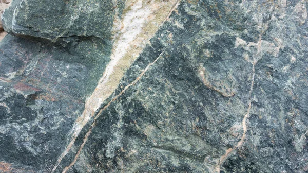 Kabartmalı dokuya sahip taş zemin ve yazı için alanı olan beyaz ve yeşil minerallerin renkli eklentileri. Yüksek çözünürlüklü taş dokusu.