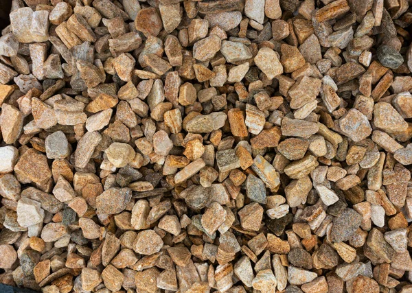 Stone chips from natural sandstone and goldstone. Background from orange and brown stones. Texture of small stones. Zlotolite for garden paths, flower beds and borders — Stock Image Stone Chips Natural Sandstone Goldstone Background Orange Brown Stones Texture Stock Picture