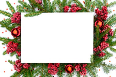 Noel ağacının tepesinde cam toplar ve viburnum dallarıyla süslenmiş beyaz boş bir kağıt parçasıyla Noel modeli. Fotokopi alanı olan yeni yıl arkaplanı kutlu olsun.