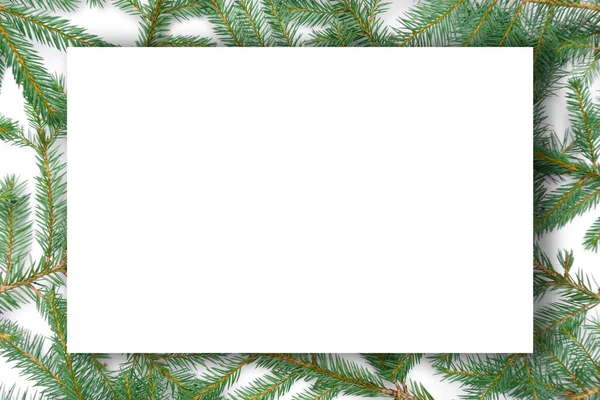 白い白紙とコピースペースとクリスマスモックアップのためのモミの枝の緑の背景 白い紙の上にモミの枝のクリスマスの背景 — ストック写真