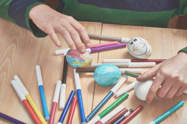 Дети рисуют пасхальные яйца с помощью мамы и с маркерами дома — стоковое фото