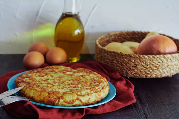 Испанский омлет с картошкой, яйцом и луком, в сопровождении оливкового масла — стоковое фото