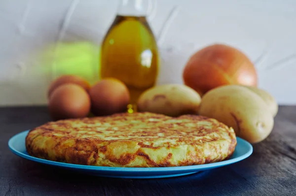 Spanisches Omelett mit Kartoffeln, Ei und Zwiebeln, begleitet von Olivenöl — Stockfoto