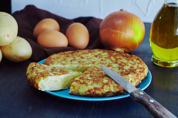 Spanisches Omelett mit Kartoffeln, Ei und Zwiebeln, begleitet von Olivenöl — Stockfoto