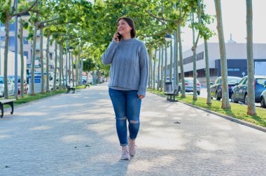 Akıllı telefondan konuşan ve akıllı telefonla mesajlar yazan genç bir kız.