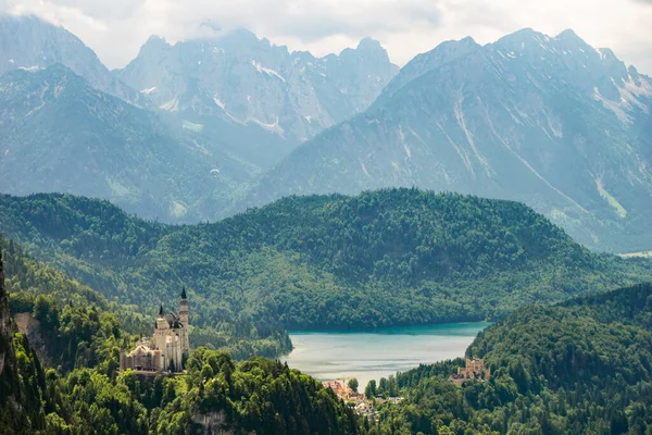 Alpen Hintergrund Mit Dem Berühmten Schloss Neuschwanstein Vordergrund lizenzfreie Stockbilder