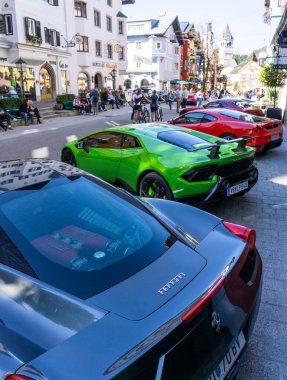 Kitzbuehel, Avusturya - 30.09.2018: Ön planda bir ferrari ve arka planda çok sayıda diğer süper araba