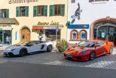 Kitzbuehel, Avusturya - 30.09.2018: Ferrari ve Lamborghini. Avusturya tatil beldesinin sokaklarında asırlık bir rekabet sergileniyor