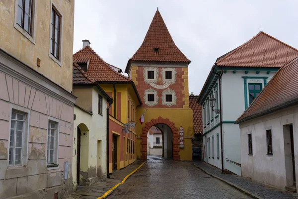Cesky Krumlov, Çek Cumhuriyeti - 28.10.2018: Eski kentteki kaldırım taşı caddesi ve ortaçağ kapısı