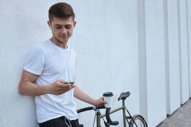 Şehirde bisiklet ile poz yakışıklı hipster adam.