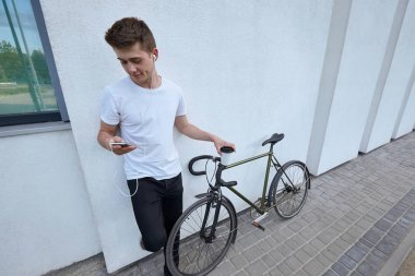 Şehirde bisiklet ile poz yakışıklı hipster adam.