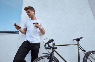 Şehirde bisiklet ile poz yakışıklı hipster adam.