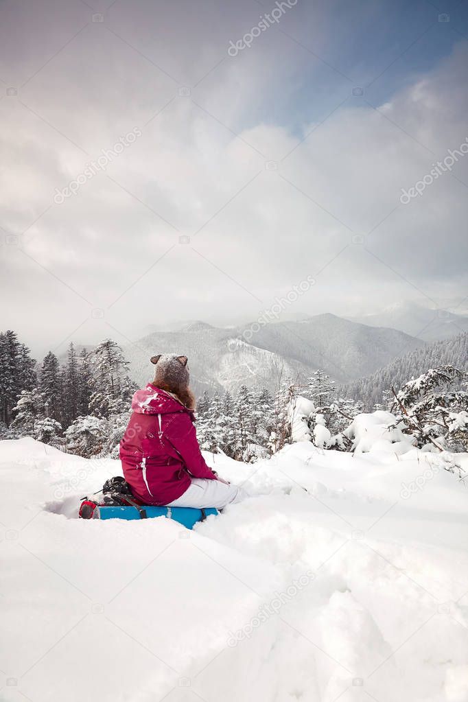 Young girl looks at mountains in winter