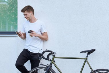 Şehirde bisiklet ile poz yakışıklı hipster adam.