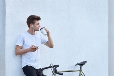 Şehirde bisiklet ile poz yakışıklı hipster adam.