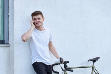 Şehirde bisiklet ile poz yakışıklı hipster adam.