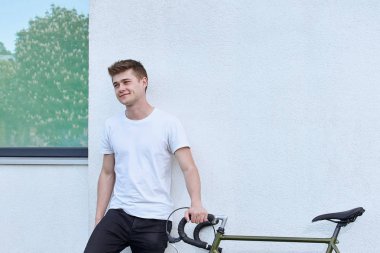 Şehirde bisiklet ile poz yakışıklı hipster adam.