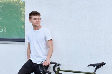 Şehirde bisiklet ile poz yakışıklı hipster adam.