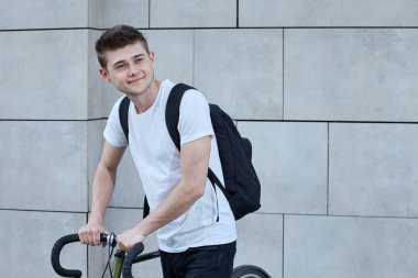 Şehirde bisiklet ile poz yakışıklı hipster adam.