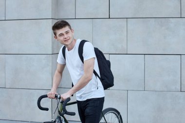 Şehirde bisiklet ile poz yakışıklı hipster adam.