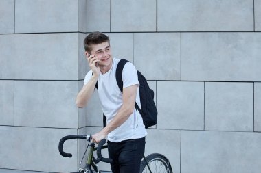 Şehirde bisiklet ile poz yakışıklı hipster adam.