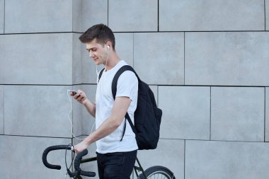 Şehirde bisiklet ile poz yakışıklı hipster adam.