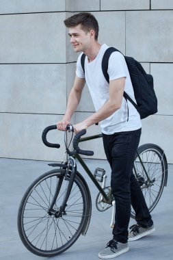 Şehirde bisiklet ile poz yakışıklı hipster adam.