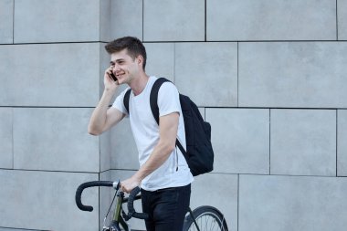 Şehirde bisiklet ile poz yakışıklı hipster adam.