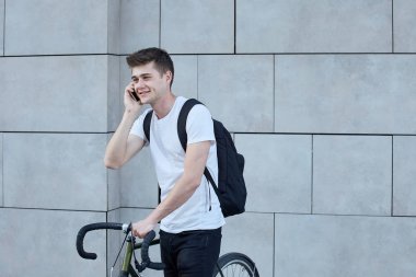 Şehirde bisiklet ile poz yakışıklı hipster adam.