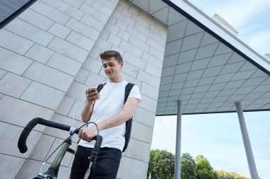 Şehirde bisiklet ile poz yakışıklı hipster adam.