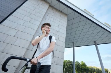 Şehirde bisiklet ile poz yakışıklı hipster adam.