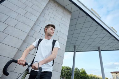 Şehirde bisiklet ile poz yakışıklı hipster adam.