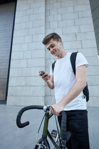 Şehirde bisiklet ile poz yakışıklı hipster adam.